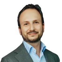 Dr. Iovieno has short hair and short dark beard.